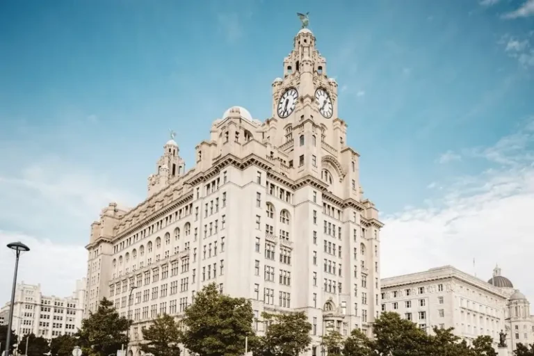 The Royal Liver Building on Liverpool's waterfront under a clear blue sky.